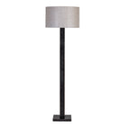 Front view of the floor lamp with a natural fabric drum shade, dark rectangular stem and square base against white.