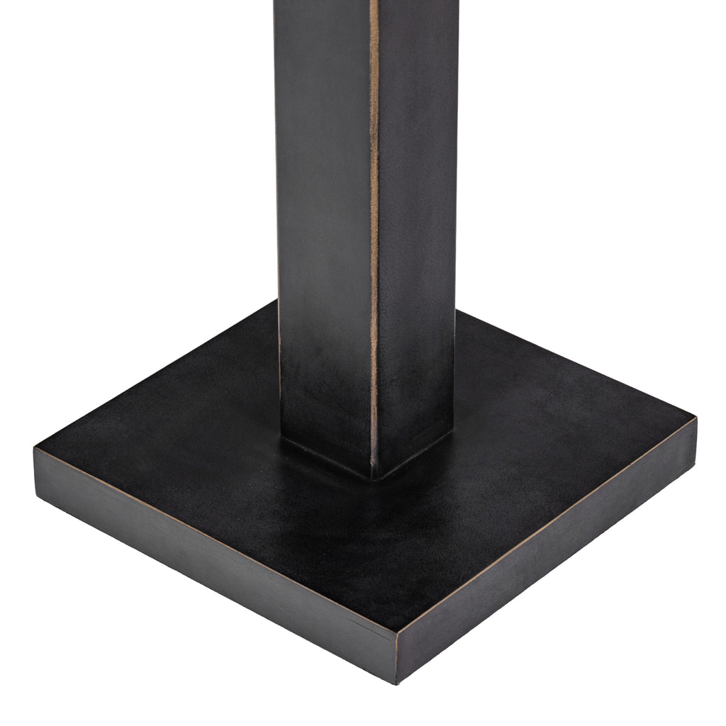 Detail of the dark square base and rectangular stem, with fine warm-toned edging along the corners.