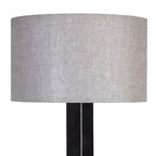 Close-up of the natural-toned drum shade showing its woven fabric texture above the dark lamp stem.