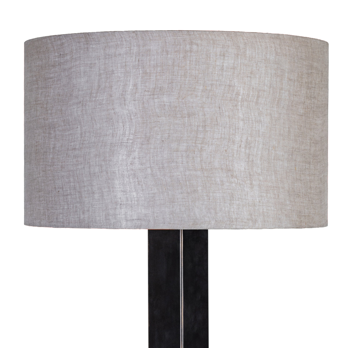 Close-up of the natural-toned drum shade showing its woven fabric texture above the dark lamp stem.
