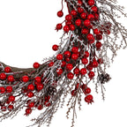 Close-up of the wreath's lower right section, showing shiny red berries, fine frosted branch sprays, pale-tipped brown pinecones and the thick brown ring beneath.