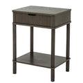 Three-quarter view of the dark grey-brown Reed & Cup Side Table, showing its reeded drawer front, plain side panel and lower shelf.