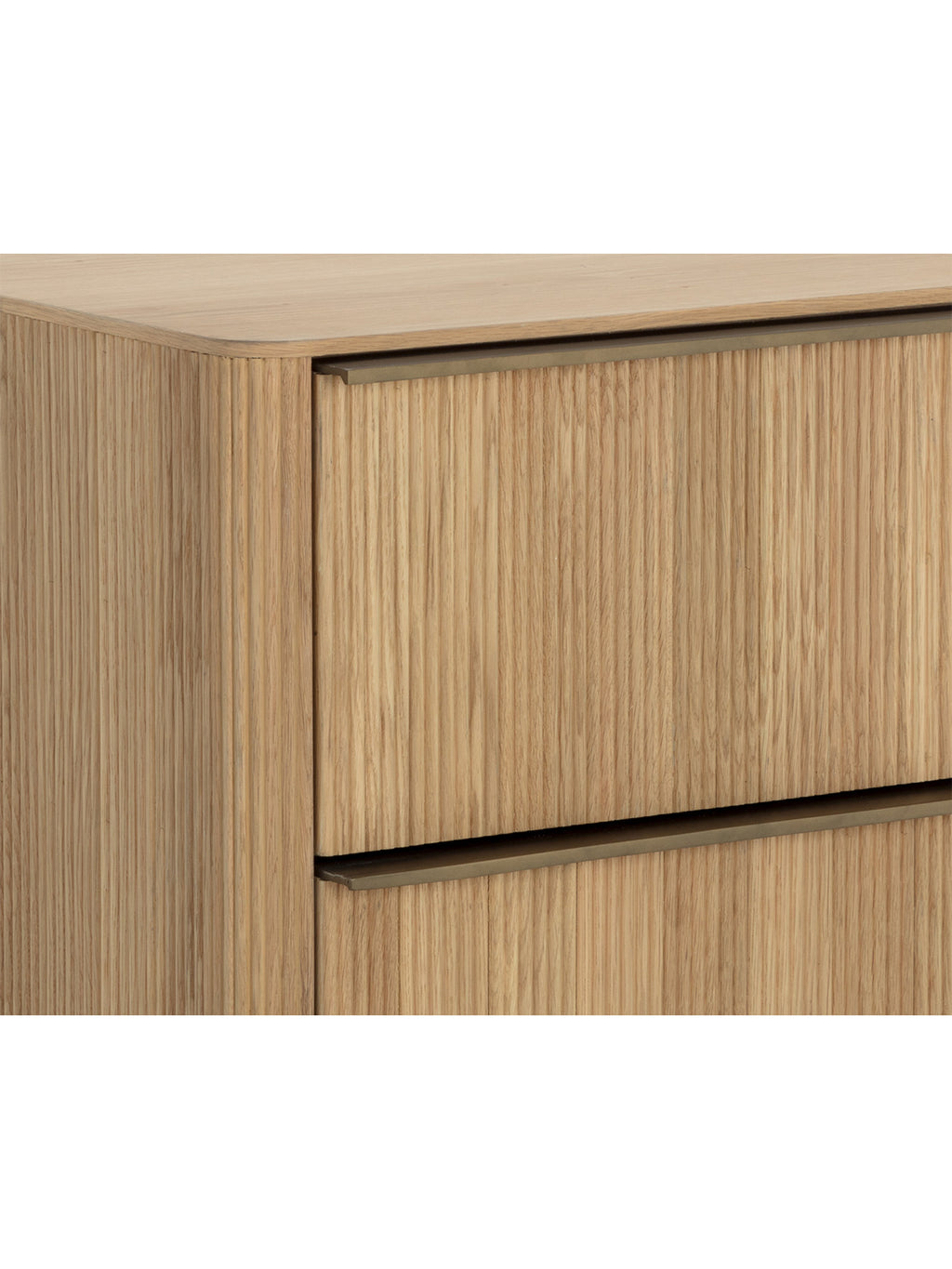 Close-up of the nightstand's rounded upper corner, wood grain, reeded drawer fronts and horizontal metal pulls.