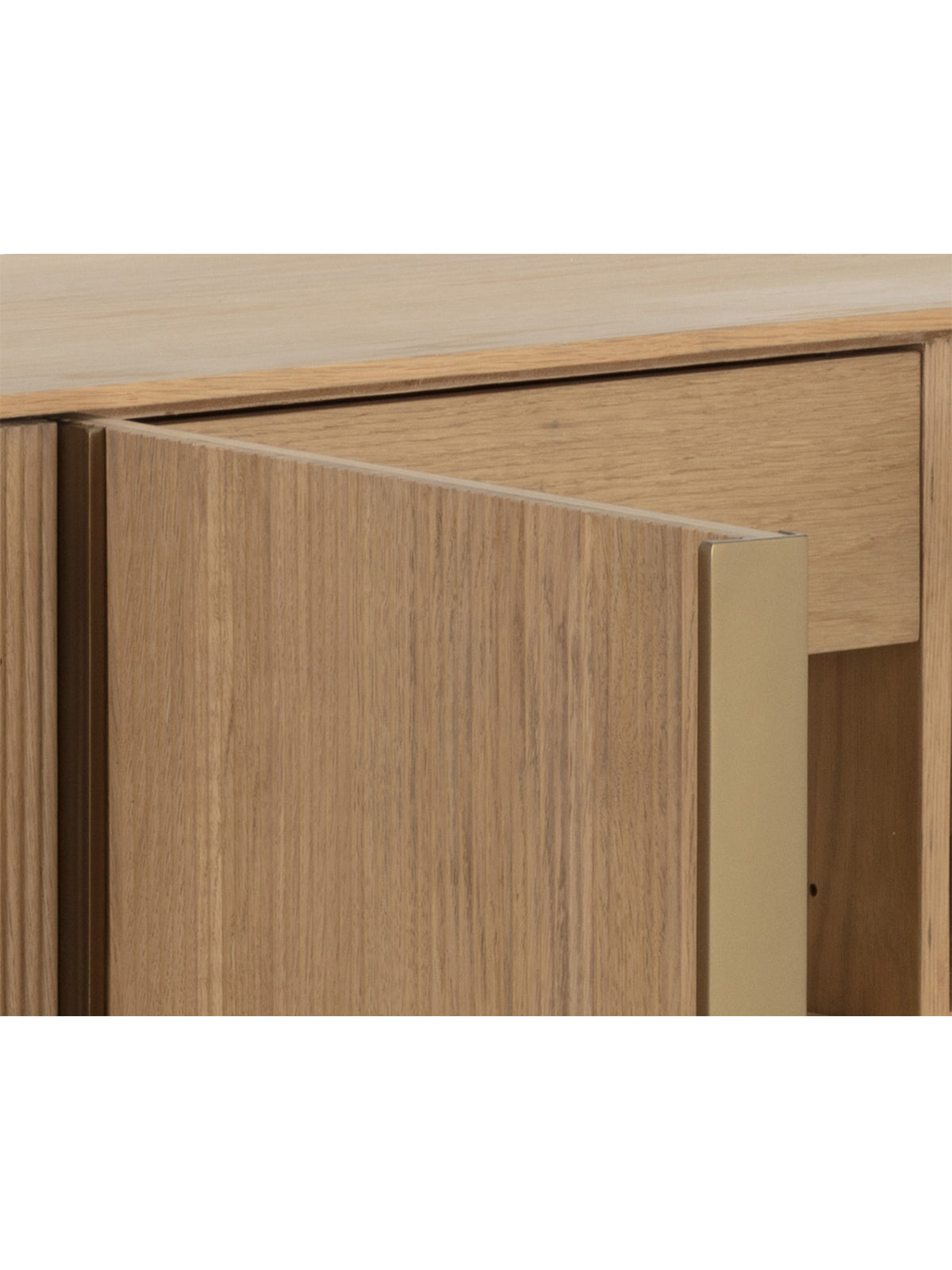 Close-up of an open sideboard door with visible oak grain and a gold-coloured edge, with an interior drawer behind it.