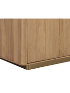 Detail of the sideboard's reeded door front, rounded wood corner and brushed gold base.