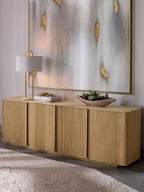Reedline Sideboard styled beneath a large abstract artwork, with a table lamp, books and a shallow bowl of succulents on top.