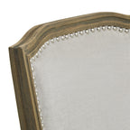 Close-up of the shaped top rail, showing brown grain-like markings, relief detailing and bright studs bordering the pale grey woven-look back panel.