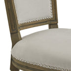 Detail of the pale grey seat and lower back panel, with rounded bright studs tracing their edges against the brown relief-detailed frame.