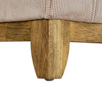 Close-up of a brown sofa foot and adjoining lower rails beneath the cream ribbed upholstery.