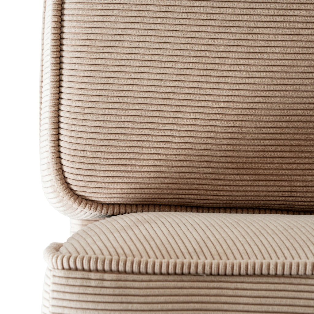 Detail of a cream back cushion above a seat cushion, showing the ribbed surface and rounded edged corner.