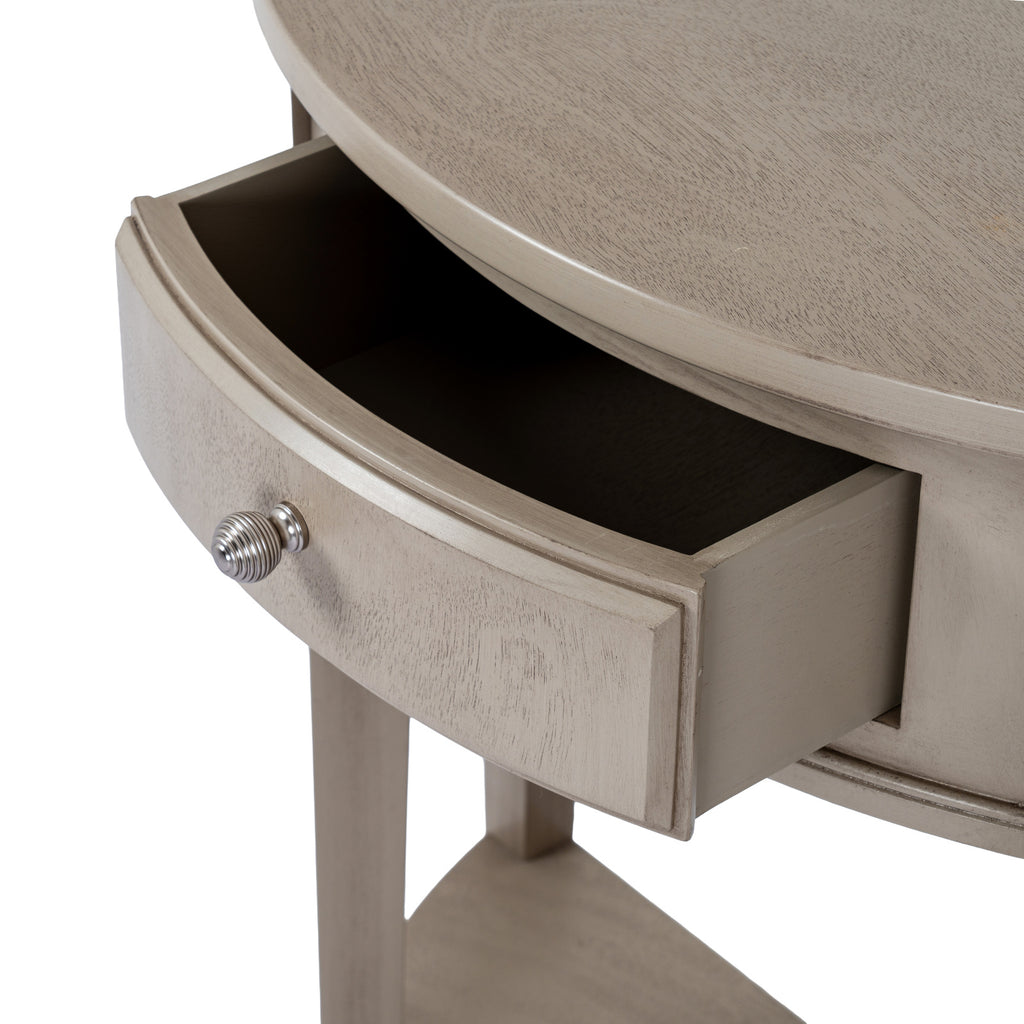 Close-up of the curved-front drawer shown open beneath the console top, with its bevelled border and ribbed silver-coloured knob.
