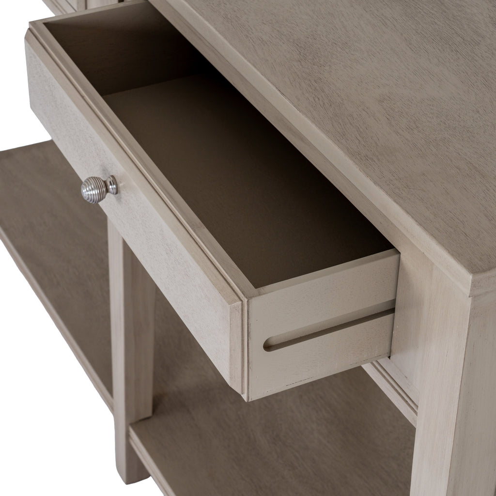 Close angled view of an open console drawer showing its empty interior, ribbed silver-coloured knob and a long groove along the drawer side.