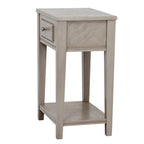 Side view of the table showing the grained side panel, tapered square legs and shaped edge of the lower shelf, with the drawer visible to the left.