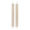 Two slender pale beige-taupe ribbed candles with white flame-shaped tips and white lower fittings against a white background.