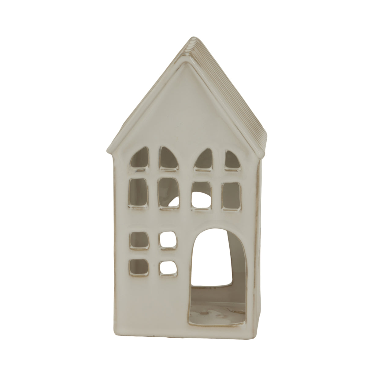 Near-front view of the cream-white house candle holder, showing rows of irregular windows and a large arched doorway on the right.