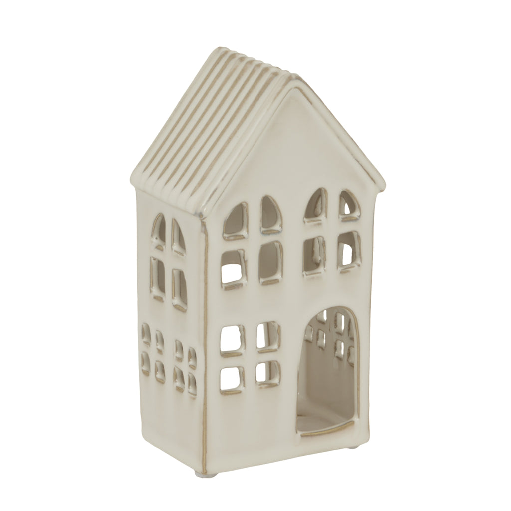 Angled view of the cream-white Windowhouse candle holder showing the ribbed roof and irregular window openings on the front and side.