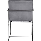 Rear view of the dining armchair with a plain grey upholstered back and a black metal rail running behind it.