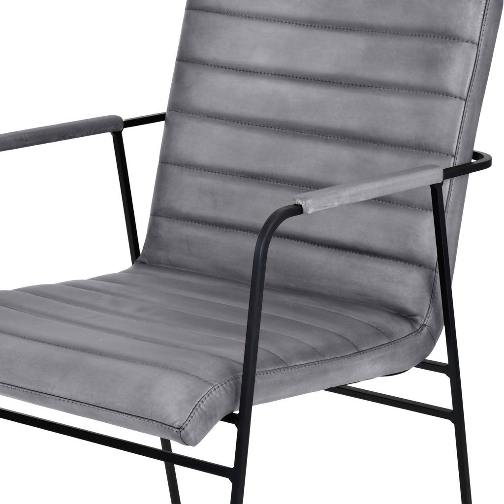 Close view of the grey leather seat and ridged back showing horizontal stitching, edge seams and upholstered armrests.