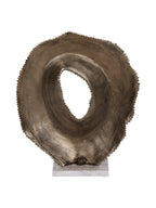Rear view of the hollow sculpture showing its curved gold surface, uneven outer edge and pale marble base.