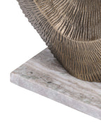 Detail of the ridged gold sculpture meeting its pale veined rectangular marble base.