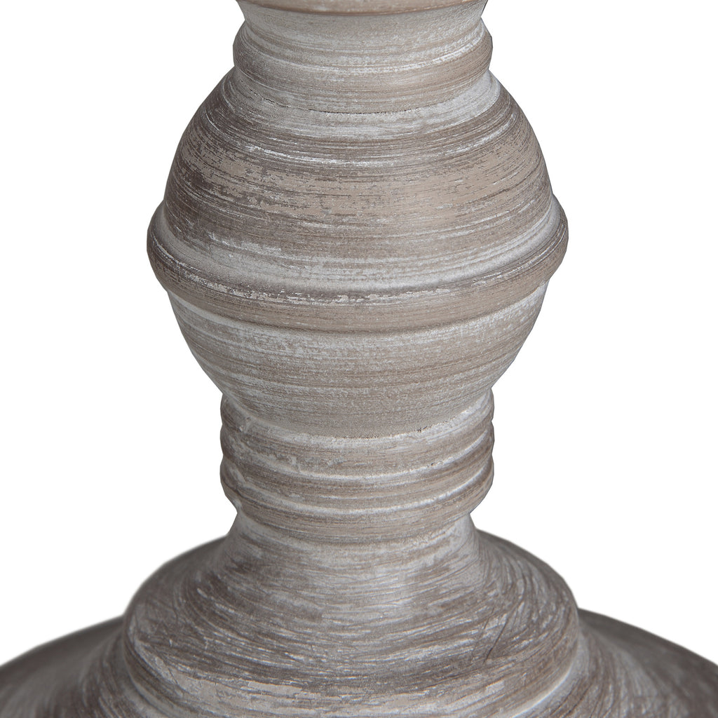 Close-up of the rounded lower lamp base, showing concentric ridges and uneven pale streaks across the grey-brown surface.