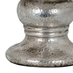 Detail of the candle holder's hammered-effect rounded body, lower bands and flared foot with dark distressed markings.
