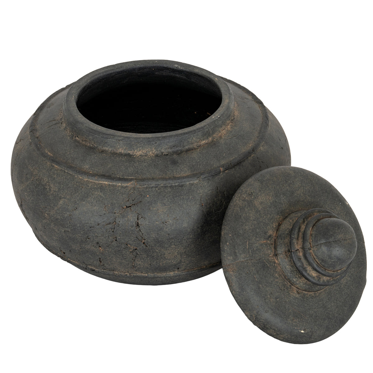 Charcoal-black pot viewed from above with its lid leaning beside it, revealing the circular opening and dark interior.