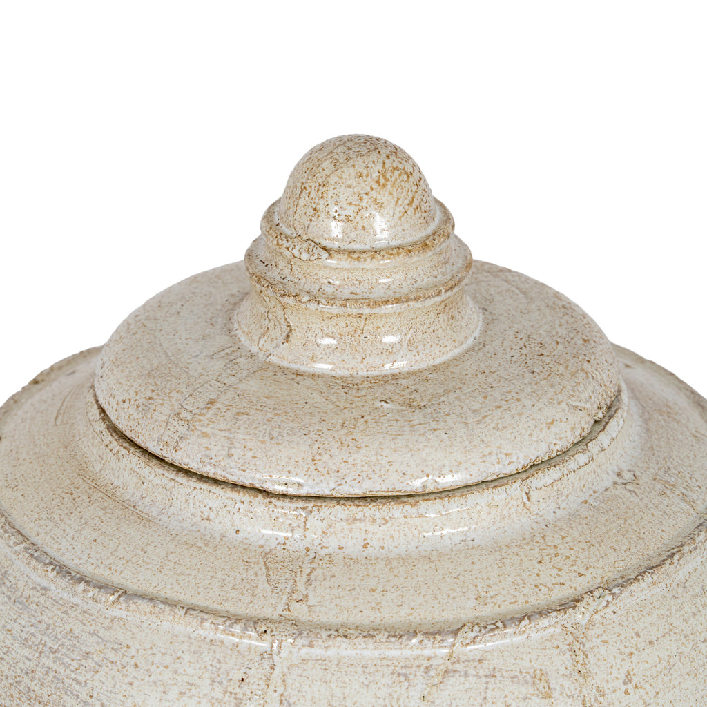 Close-up of the pot's stepped lid and domed finial, showing concentric rings, glossy highlights and irregular brown markings.