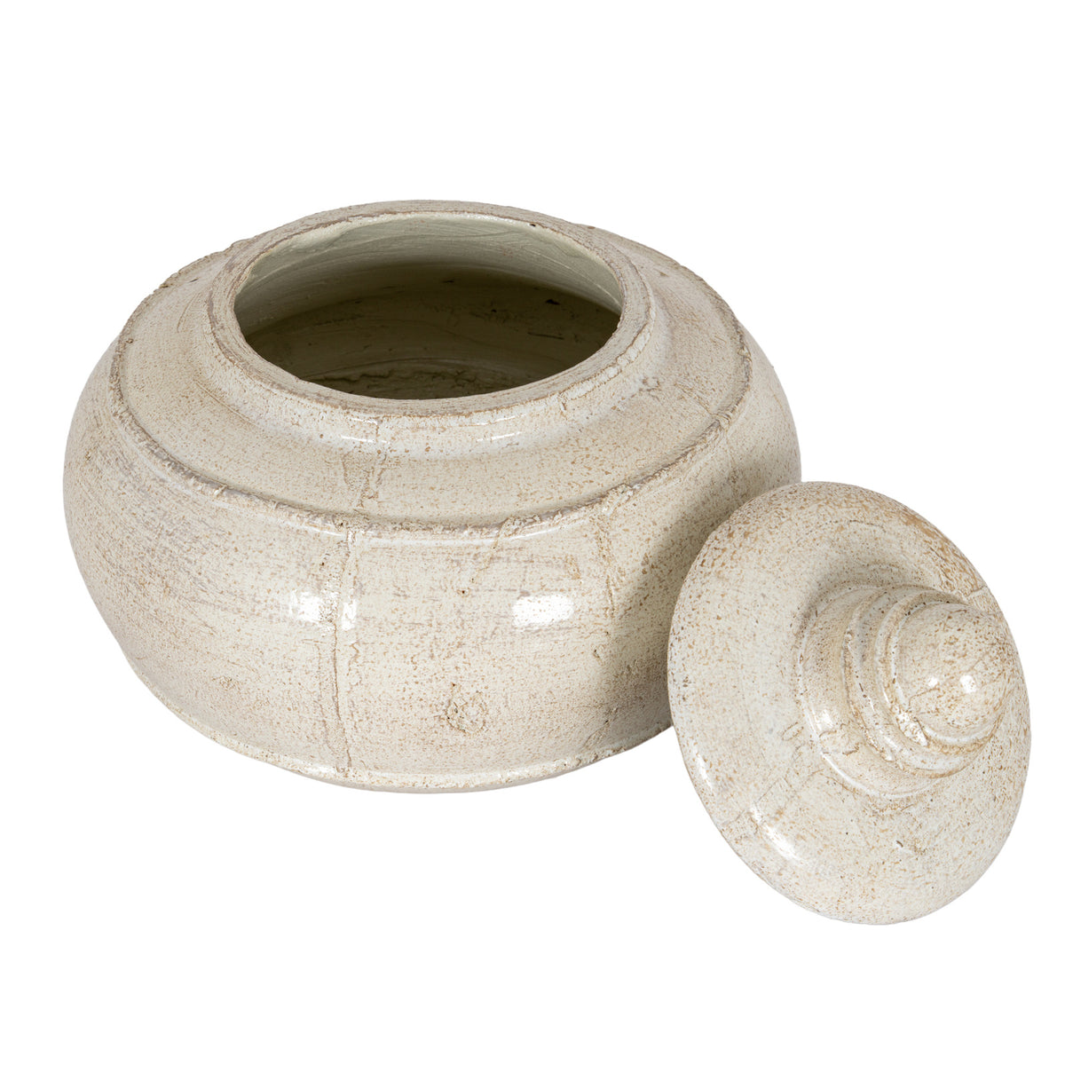 Elevated view of the open cream pot with its lid leaning to the right, showing the interior and beige-brown speckling.