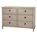 Angled front view of the pale beige-grey Ringline chest, showing six bordered drawers with black ring pulls, its right side and short shaped feet.