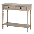Three-quarter front view of a pale beige-grey console table with two framed drawers, black ring pulls, four slender legs and a low shelf.