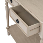 Angled close-up of an open console-table drawer, showing its empty interior, black ring pull and the grained top above.