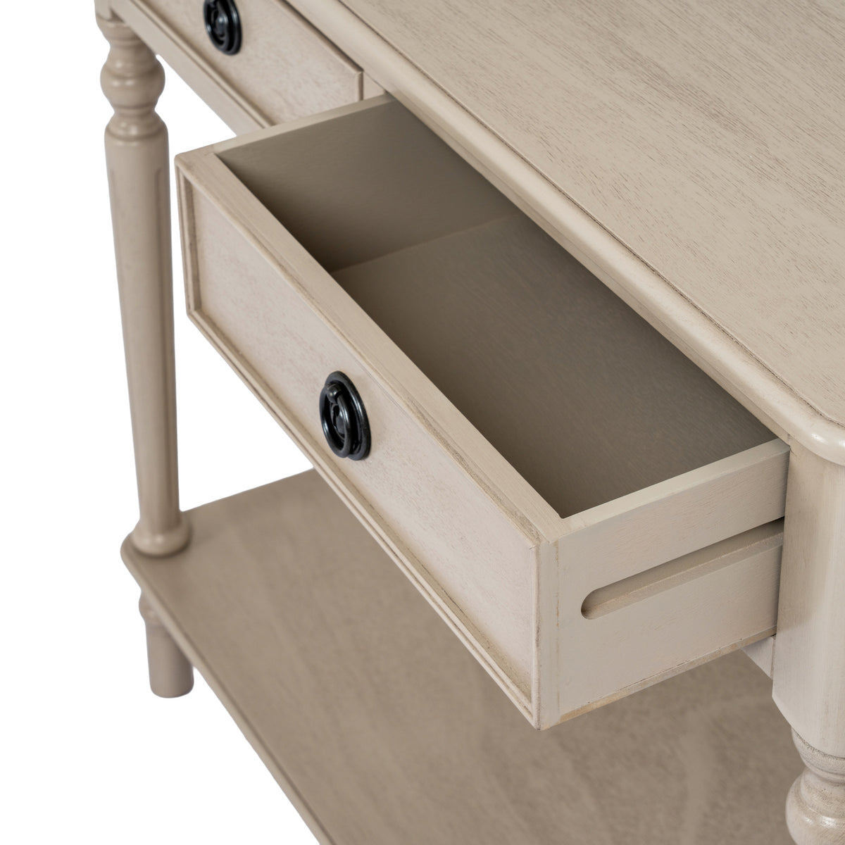 Angled close-up of an open console-table drawer, showing its empty interior, black ring pull and the grained top above.