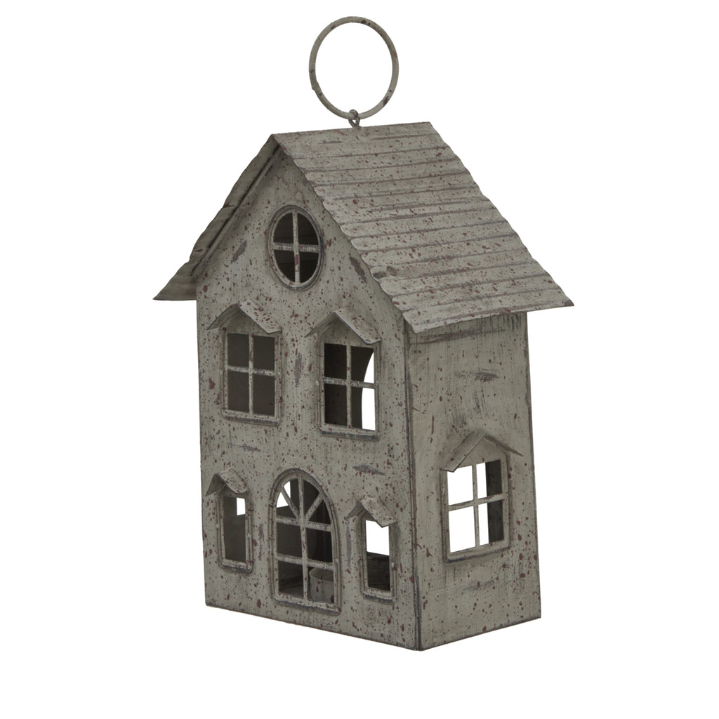 Angled view of the weathered house candle holder showing the ridged roof, front façade and pierced side window.
