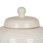 Close-up of the rounded lid knob and glossy concentric rings, with warm beige shading along the grooves.