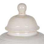 Close-up of the jar's rounded finial and ribbed domed lid, showing glossy cream-white surfaces and warm beige accents.