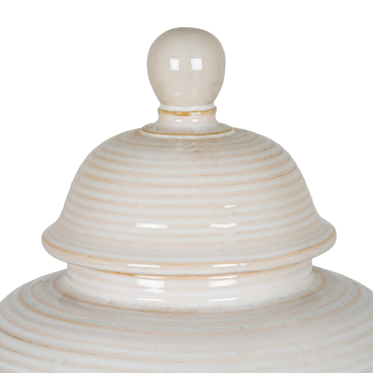 Close-up of the jar's rounded finial and ribbed domed lid, showing glossy cream-white surfaces and warm beige accents.