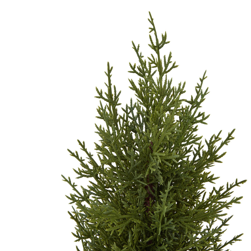 Close-up of the tree decoration's fine green branching sprays and irregular pointed tip.