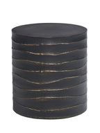 Black round drum side table with wavy horizontal ridges traced in brass-coloured paint, shown against white.