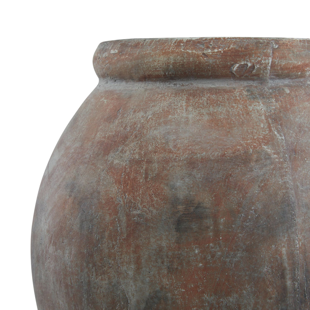 Close-up of the planter's rolled lip and curved shoulder, with pale grey streaks and darker patches across the brown finish.