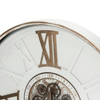 Close-up of the clock's gold-toned XII numeral, distressed rim and upper section of the numbered ring around the cogs.