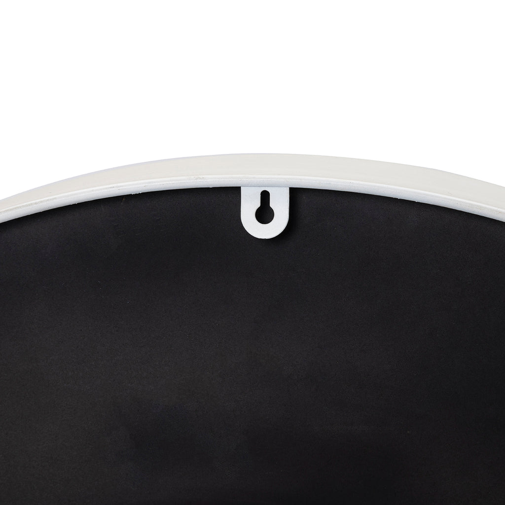 Close-up of the keyhole-shaped opening in a white tab at the upper edge of the clock's black back.