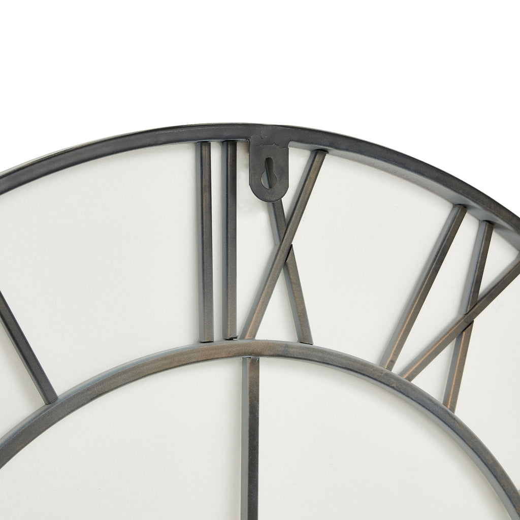 Close-up of the clock's upper rear framework, showing the curved outer ring, Roman numeral bars and hanging tab with a keyhole-shaped opening.