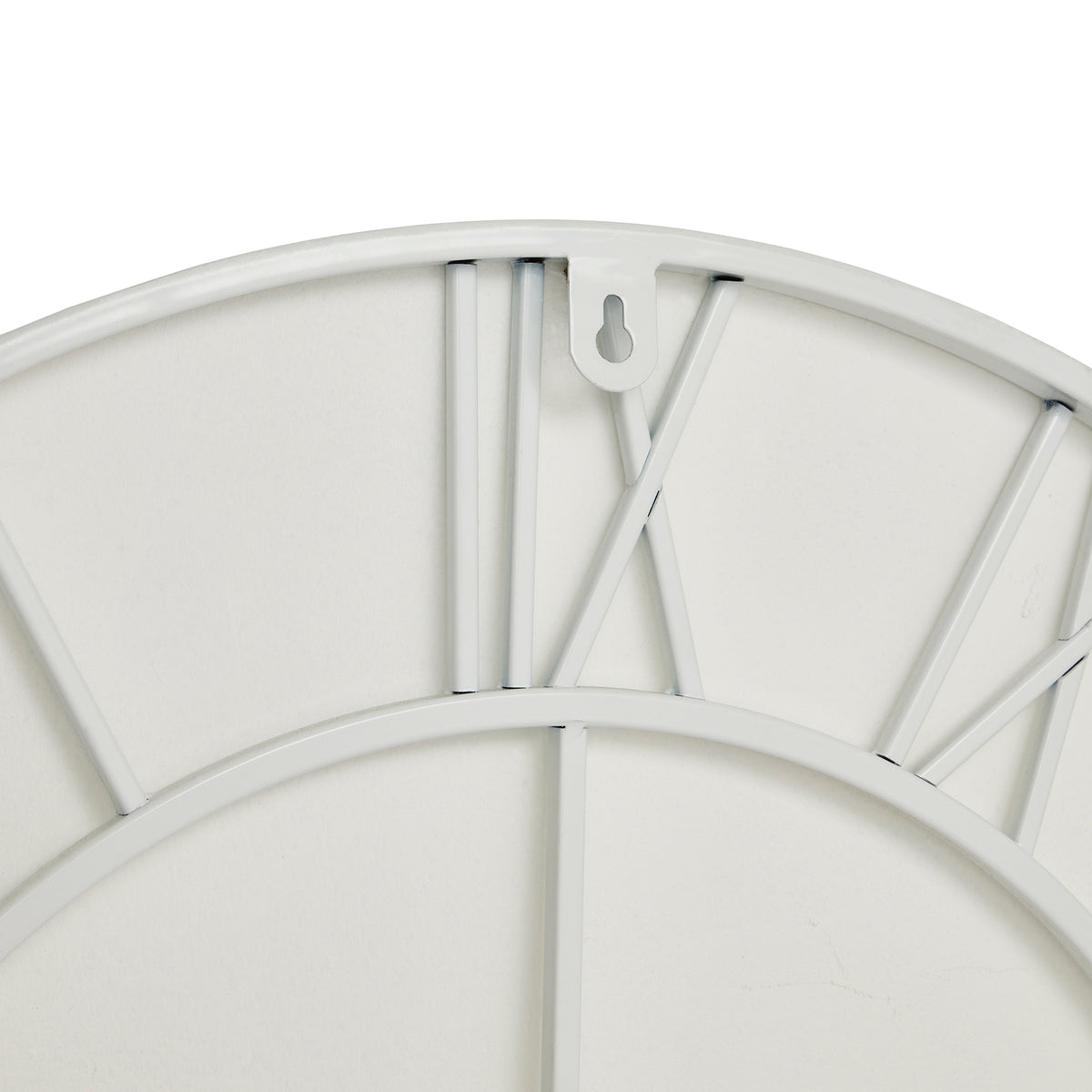 Rear close-up at the top of the white clock, showing the XII numeral framework, curved outer and inner rings and keyhole-cut hanging tab.