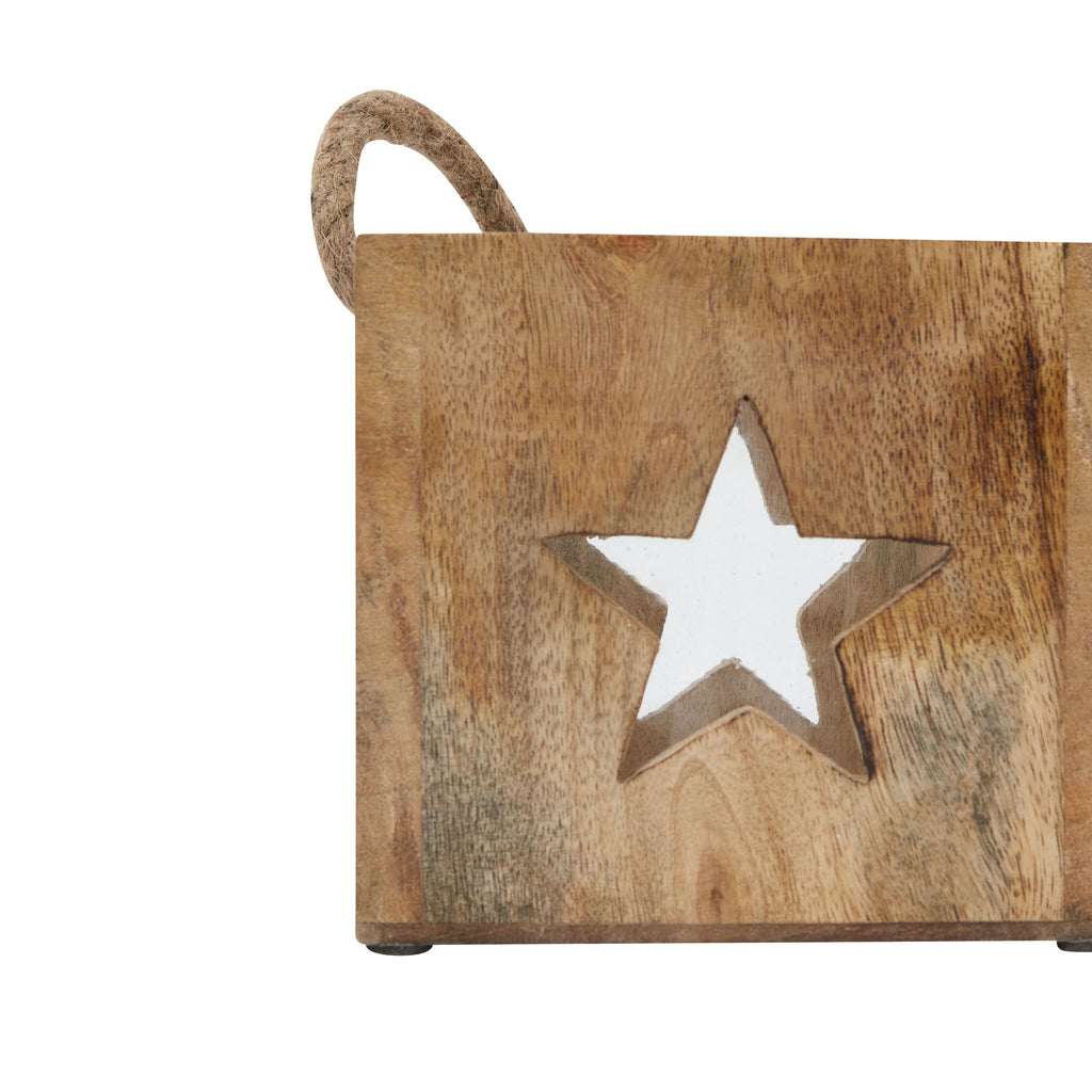 Close-up of a star-shaped opening in the brown tea light holder, with darker grain markings and part of the rope loop above.