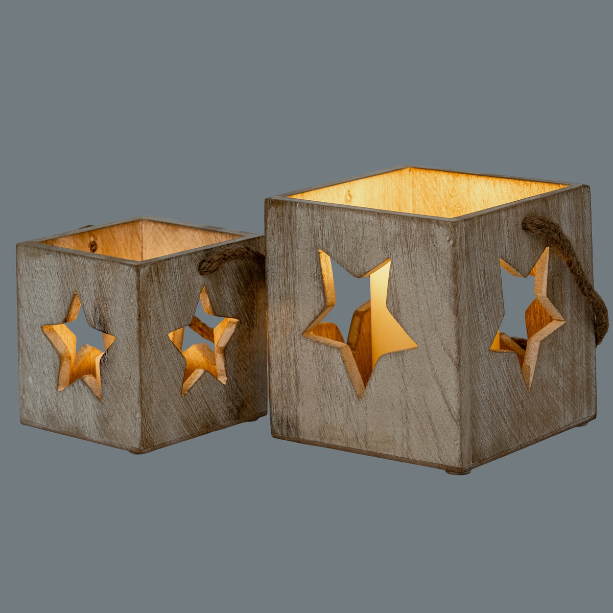 Two differently sized star candle holders shown side by side, with warm light visible inside and through their star openings.