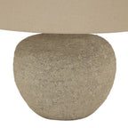 Close-up of the lamp's rounded base, showing the rough beige surface and darker grey mottling beneath the shade's lower edge.
