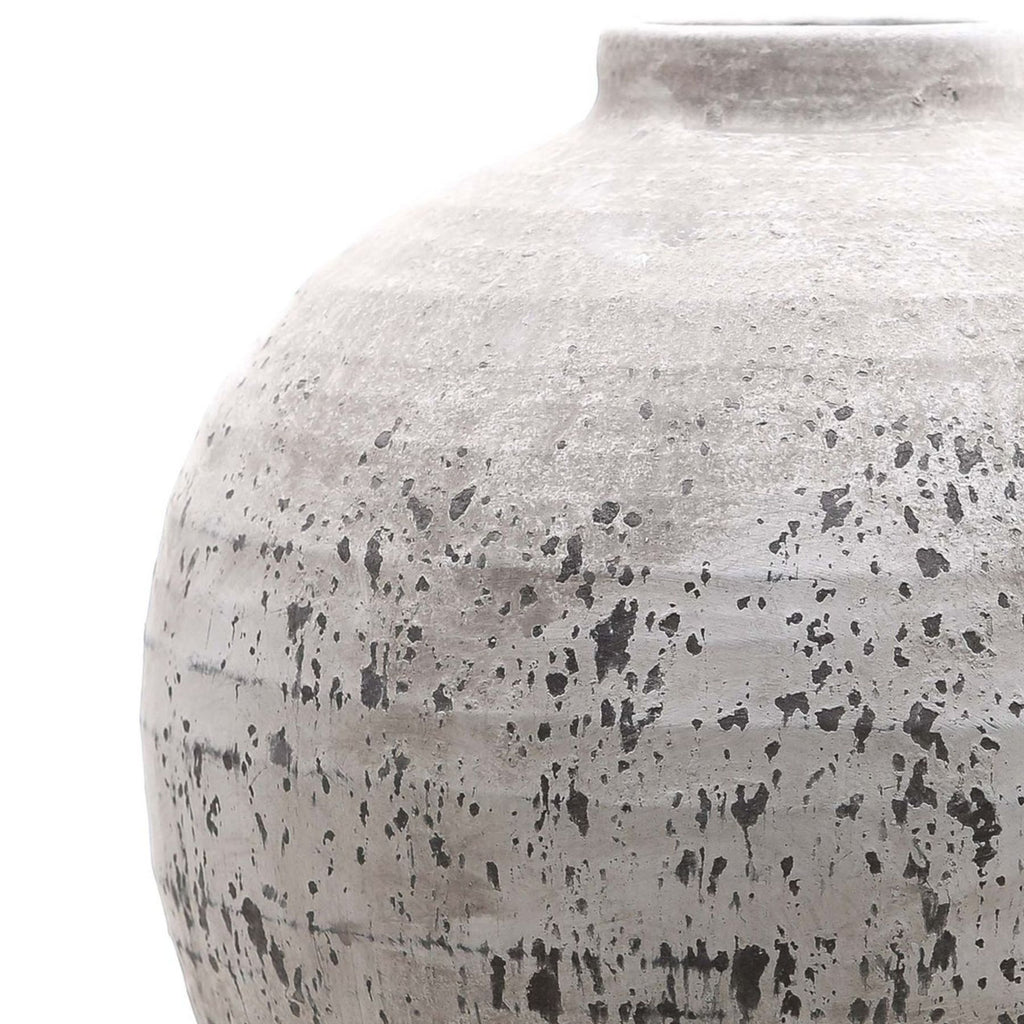 Close-up of the Rough Orbit Vase showing its curved shoulder, short neck and pale textured finish with dark speckles, streaks and horizontal bands.