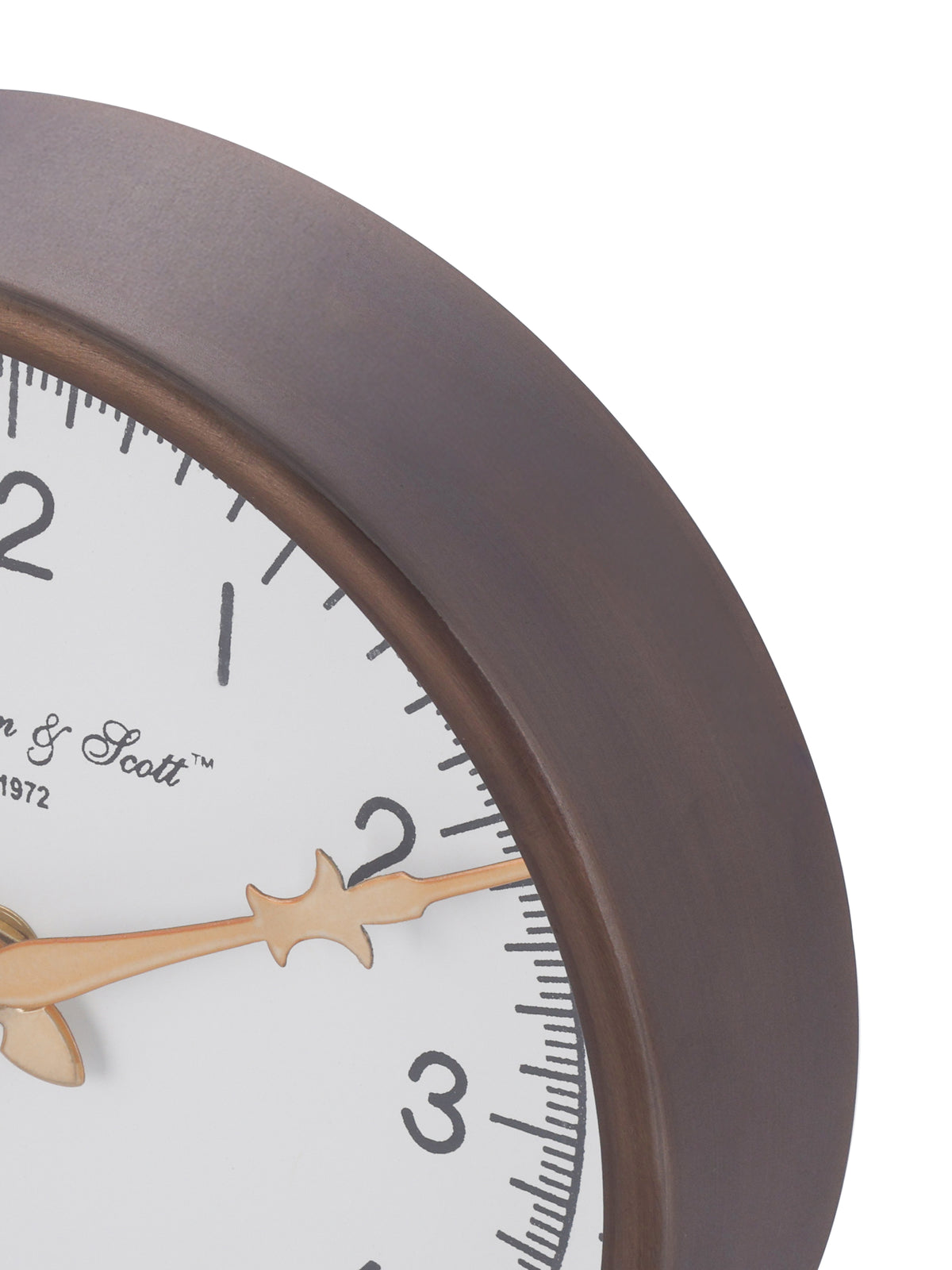 Close-up of the clock's bronze-toned rim beside black minute marks and a decorative gold-toned hand.