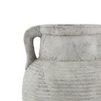 Close-up of one curved handle beside the short neck and ribbed shoulder, with crackle-like markings in the weathered finish.